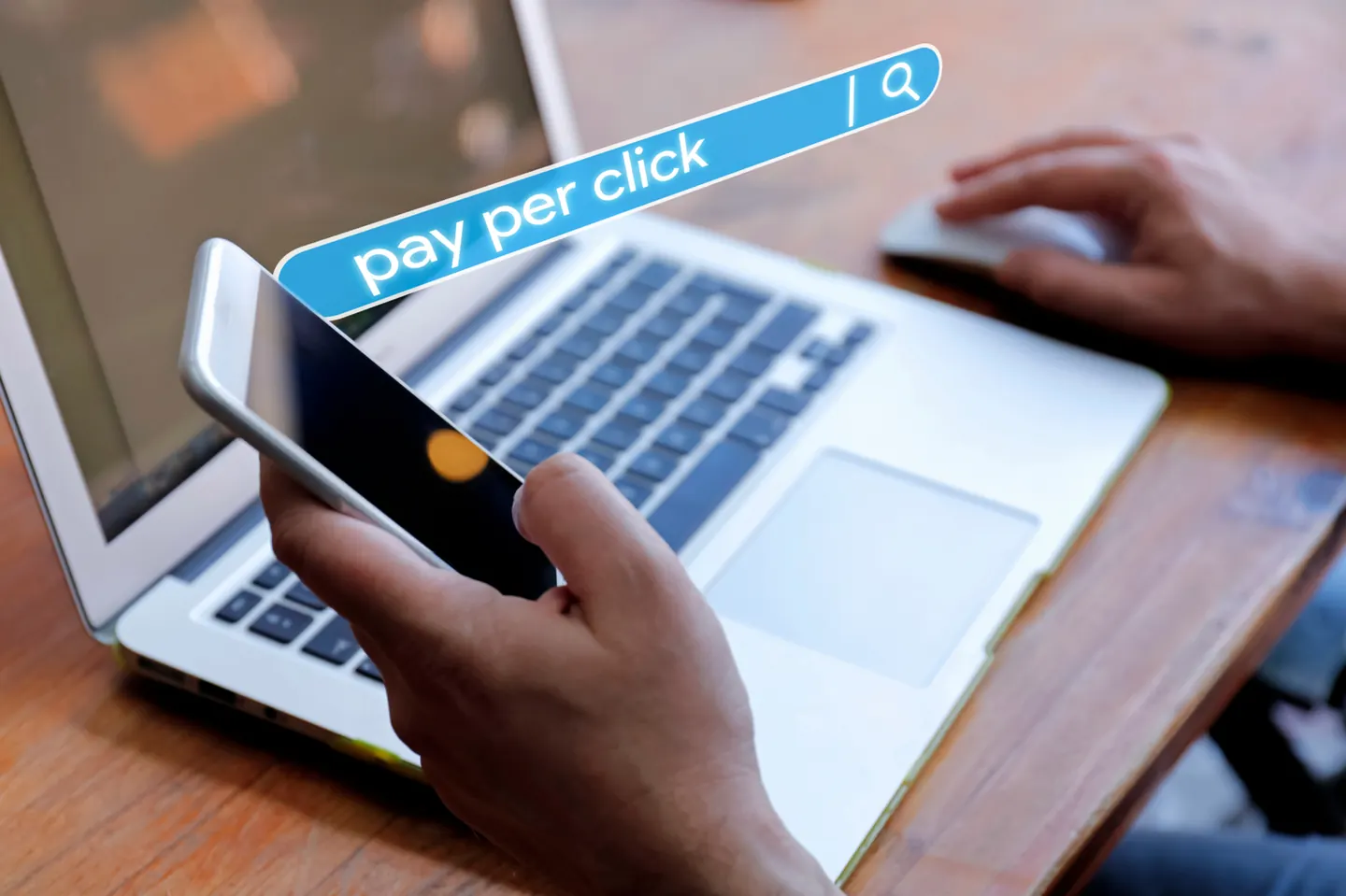 Person searching pay-per-click results on a laptop and phone