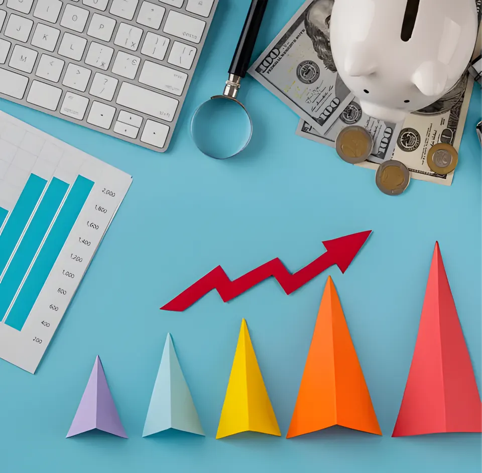 Paper chart arrows rising beside a calculator and cash