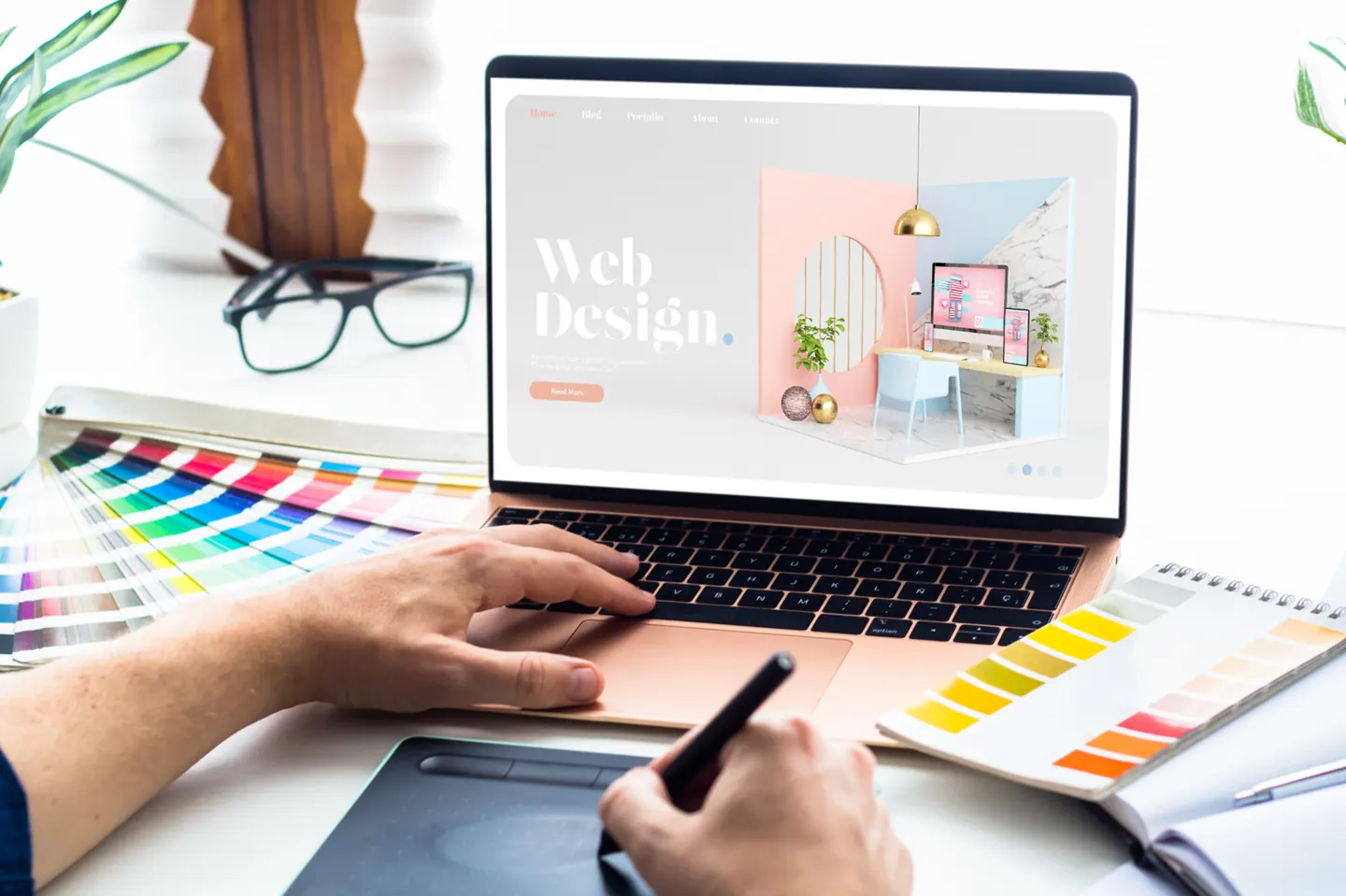 Designer sketching a website layout beside color swatches
